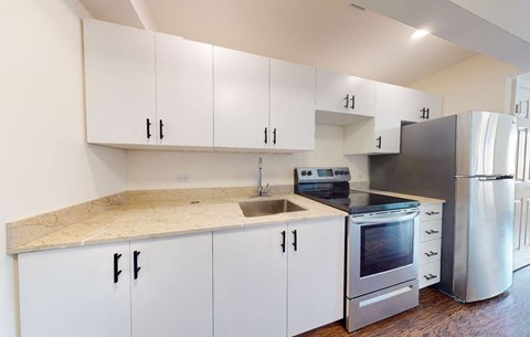 a kitchen with white cabinets and stainless steel appliances