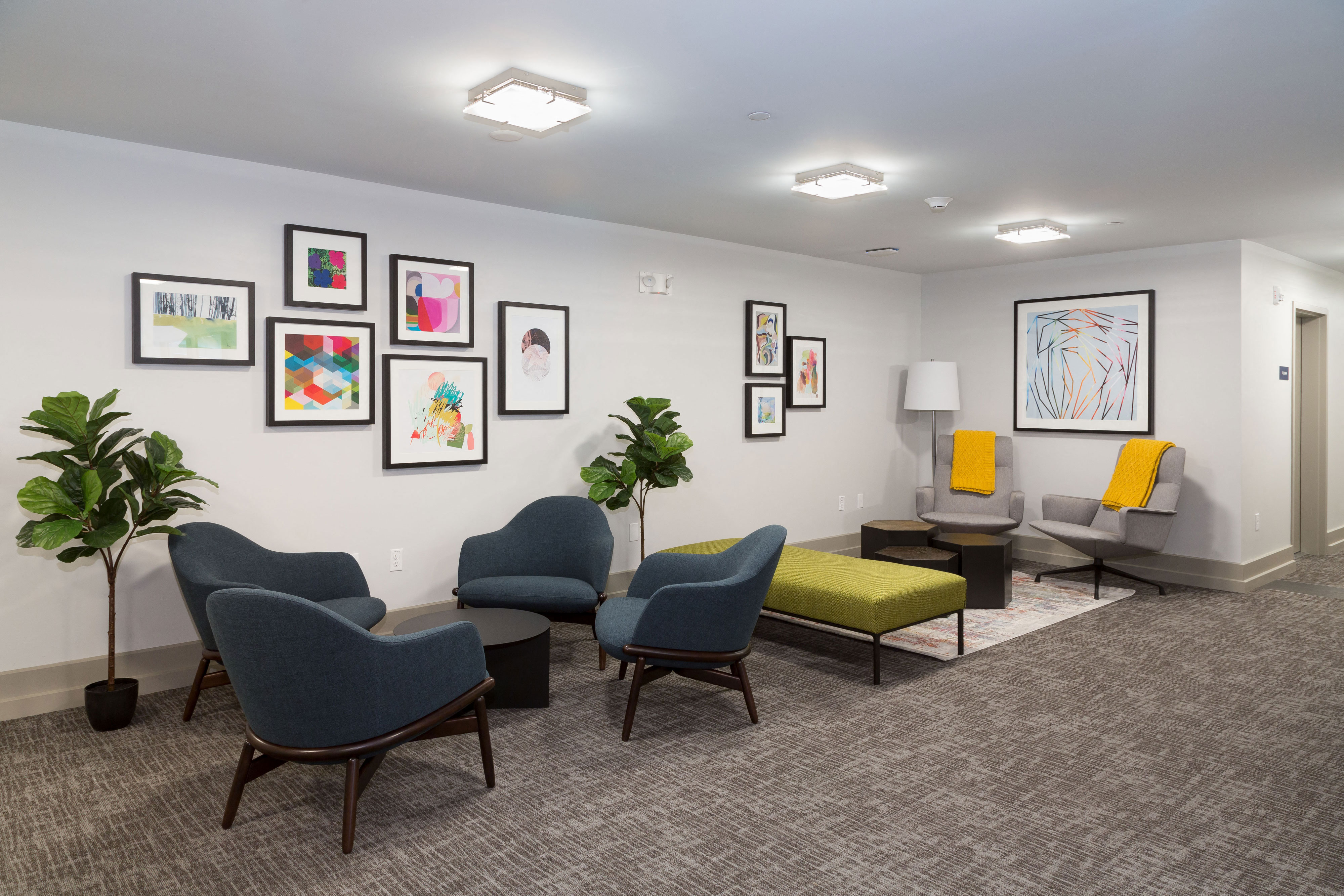 a living room with chairs and pictures on the wall