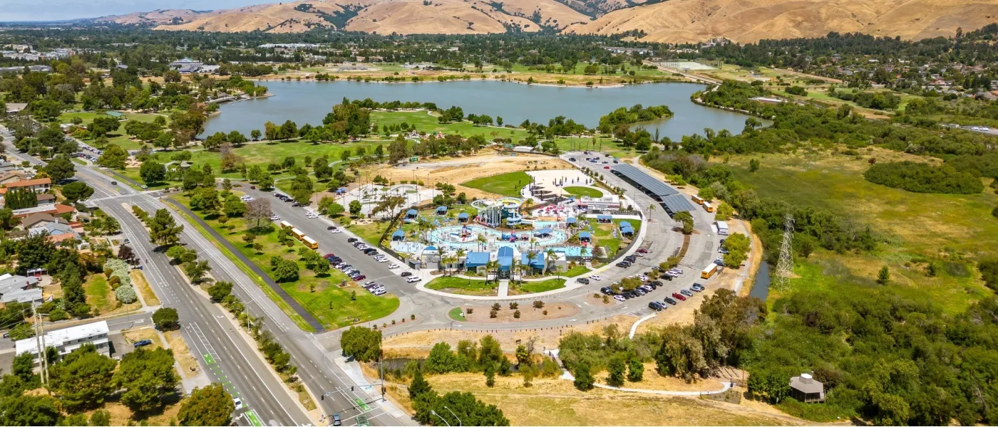 This aerial view of Aqua Adventure Waterpark in Fremont, CA, surrounded by green lawns and families enjoying the day, highlights one of the many community amenities that make affordable neighborhoods in Fremont appealing to residents seeking both recreation and value.