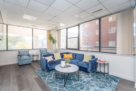 a living room with blue couches and a coffee table in front of a window