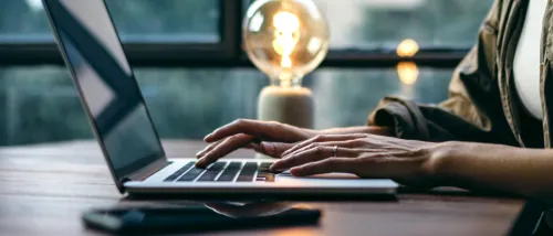 Hands of a renter typing on a laptop and applying for multiple apartments at once.