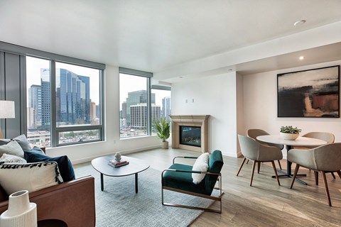 a living room with a large window and a table and chairs