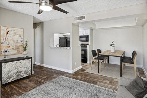 the living room and dining room of an apartment with a table and chairs