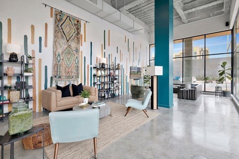 a living room with couches and chairs and a rug on the wall