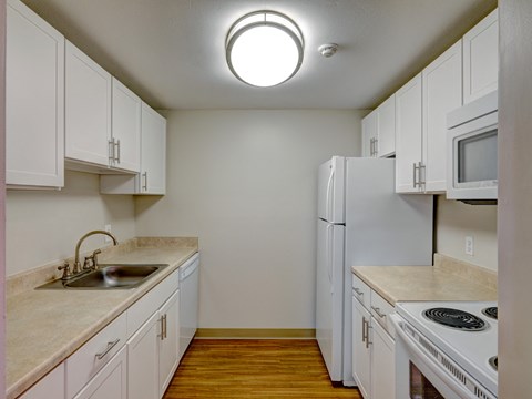 a kitchen with white cabinets and a sink and a refrigerator