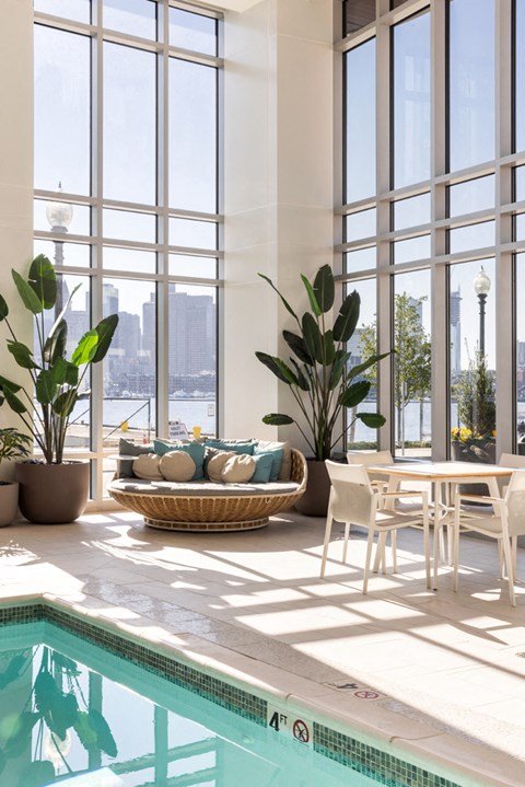 a living room with a swimming pool and a table and chairs