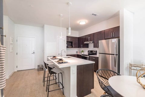 a kitchen with a large center island with a breakfast bar