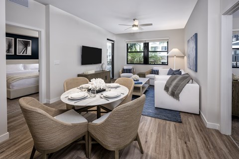 a living room and dining room with a table and chairs