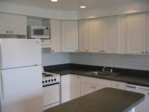 a kitchen with white appliances and white cabinets