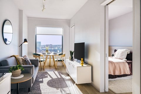 a living room with a couch and a table and a bed