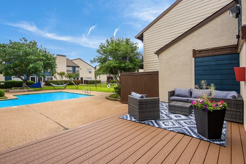 a backyard with a swimming pool and patio furniture