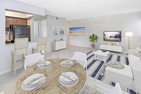 a living room and dining room with a table and chairs