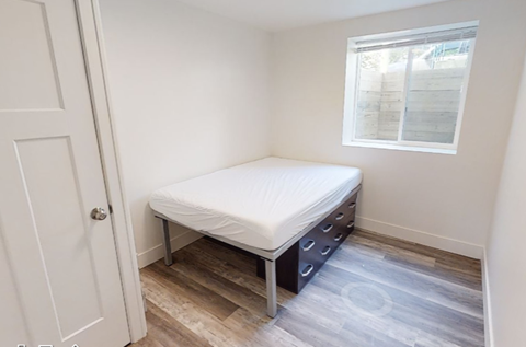 a small bedroom with a bed and a window